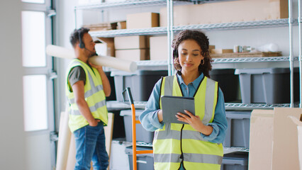 Woman Using Digital Tablet With Male Colleague With Down Syndrome In Warehouse