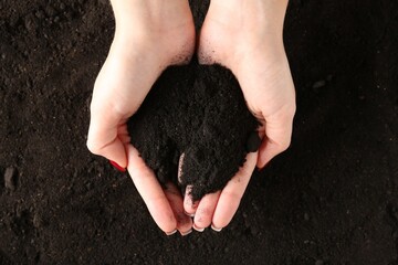 Woman with pile of fresh soil, top view