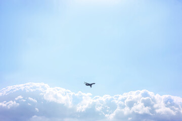 Airplane flying in beautiful blue sky, bottom view