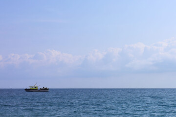 Picturesque view of wavy sea with small ferry