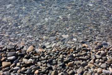 Many beautiful pebbles in water, closeup view