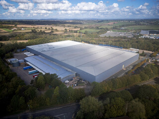 Modern warehouse and distribution depot seen from above with metal cladding, parking bays and...