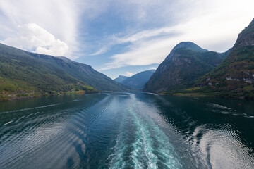 Amazing sunset views of the Sognefjord in Norway during a amazing Summer evening seen from the backside of a ship, when cruising through the unique natural landscape of Norway and its fjords, while th