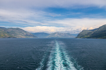 Amazing sunset views of the Sognefjord in Norway during a amazing Summer evening seen from the backside of a ship, when cruising through the unique natural landscape of Norway and its fjords, while th