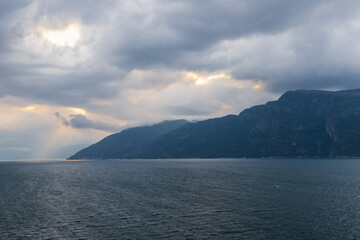 Amazing sunset views of the Sognefjord in Norway during a amazing Summer evening seen from the backside of a ship, when cruising through the unique natural landscape of Norway and its fjords, while th