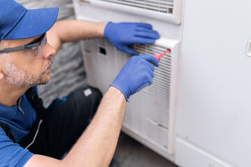 Repairman fixing AC outdoor unit.