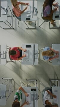 Children Typing on Keyboards in Computer Lab. Kids Studying at Computers in Bright Computer Lab, Learning Technology Developing Computer Skills. Concept of Modern Education. Top View. Vertical Shot.
