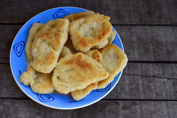 Traditional Bulgarian home made deep fried  patties  covered with sugar  оn rustic backgroud.Mekitsa or Mekica,  on wooden  rustic  background. Made of kneaded dough that is deep fried 