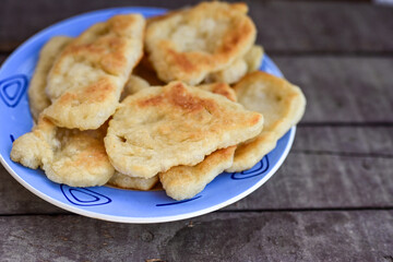 Traditional Bulgarian home made deep fried  patties  covered with sugar  оn rustic backgroud.Mekitsa or Mekica,  on wooden  rustic  background. Made of kneaded dough that is deep fried 