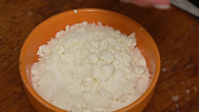 Cottage cheese, sugar, mixing fresh breakfast ingredients in orange bowl
