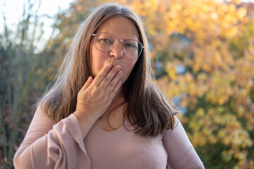 Surprised, Shocked middle-aged woman with long hair outdoors, portrait shocked terrified adult...