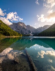 Serene mountain lake reflecting a clear sky and clouds