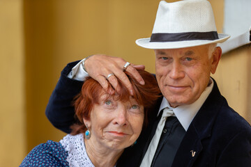 Elderly couple engaged in warm embrace while enjoying a moment of affection in a cozy setting
