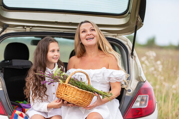 Mother and daughter enjoying a summer day, gathering flowers and sharing smiles in a scenic field