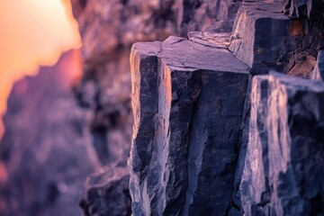 Dramatic close-up of jagged rock formations, illuminated by warm golden light contrasting with cool purple shadows, evoking a serene natural landscape.