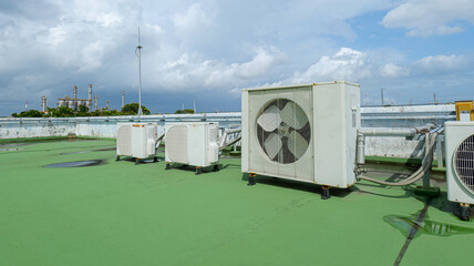 Windows-type air conditioners installed on the rooftop of a building, symbolizing cooling technology, energy management, urban infrastructure,