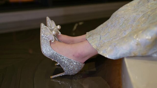 The girl shows off her beautiful sparkling crystal shoes on her feet.