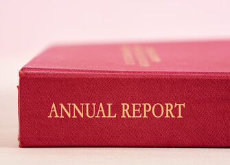 Red annual report with golden letters lying on a white surface