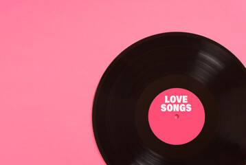 Vinyl record with pink label saying love songs on pink background