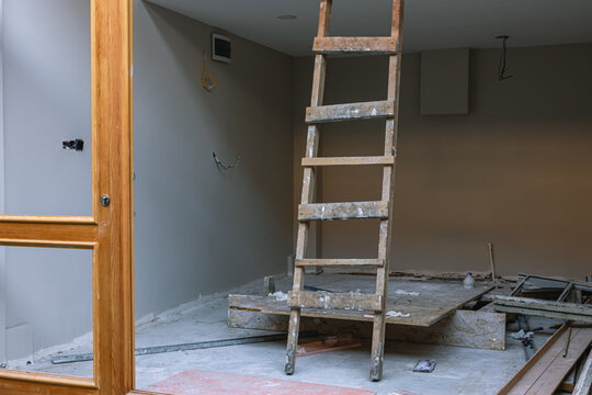 Renovation of an apartment in an old house. A wooden staircase is installed in the house for work at height. Carrying out repairs in the building and laying communications.