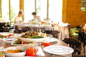 Savory meat with potatoes and veggies on table in cozy restaurant.