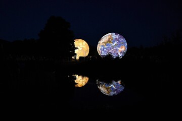 Huge illuminated models of planets and earth in the evening at the observatory. Brno Czech Republic Festival of planets.