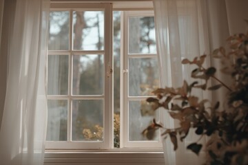 Soft natural light enters through a white-paned window with sheer curtains, offering a peaceful view of trees and foliage outside