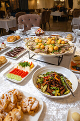 Top view of a lavish table with roasted meat, salads, desserts, and appetizers.