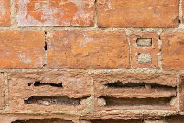 Eroded brick wall showing signs of severe damage and decay