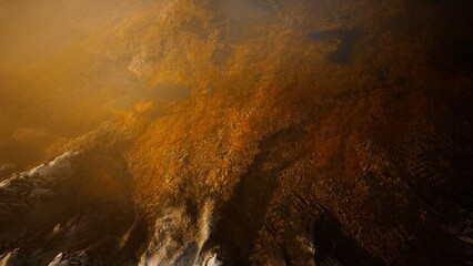 A tranquil mountain lake reflects golden hues as the sun sets behind rugged peaks. The water shimmers, creating a breathtaking interplay of light and natures beauty during dusk.
