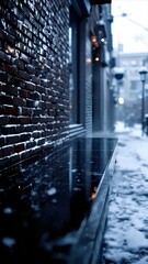A reflective black marble counter runs alongside a snowy brick building wall in a dark city alley. Blurred figures walk in the cold, dramatic distance