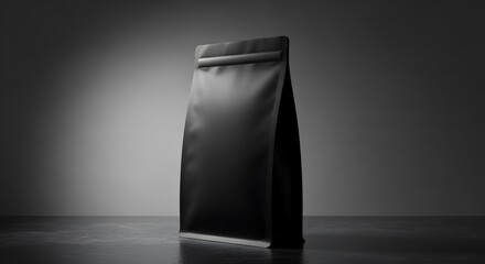 Matte black pouch on dark stone surface, gradient gray background, soft top-down studio lighting, professional packaging product photography