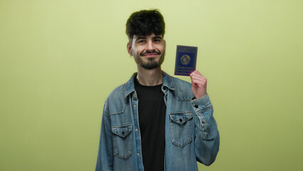 Handsome man holding belarus passport proudly against isolated yellow wall background showing...