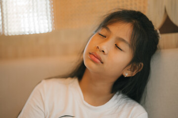 tired preteen girl sleeping on sofa at home, lying asleep, feeling lack of energy
