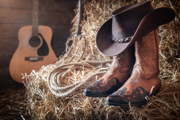 Cowboy hat guitar and boots in barn, country music festival live concert or rodeo background