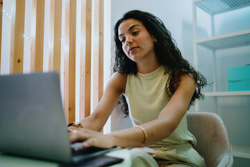 Smiling woman on laptop video call, radiating positive collaboration and connectivity in remote work culture enabled by digital tools.