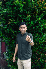 Man gesturing with a serious facial expression outdoors