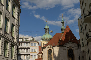 Facade of a house in Prague on a sunny day, showing architectural details in bright light. Urban architecture