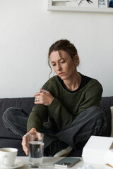 Young woman sitting alone at home reflecting on her feelings and struggles with depression