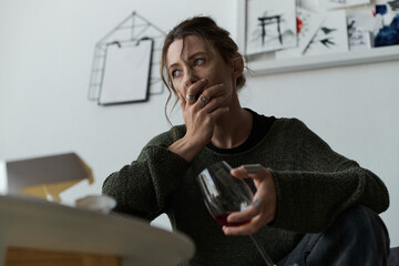 Young woman sitting at home feeling overwhelmed and lost during a quiet evening moment