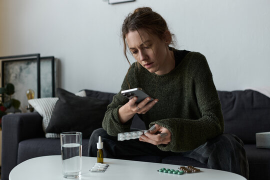 Young woman struggles with depression while sitting alone at home in a quiet moment