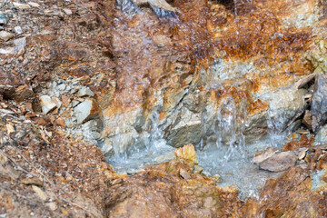 Close-up of mineral water trickling over mountain rocks