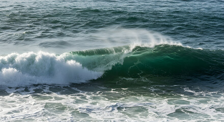 Fototapeta premium Dynamic Ocean Wave Crashing Against the Shore Under Bright Sunlight at a Coastal Beach