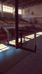 An empty college basketball gym with a basketball court and a hoop placed at the center.