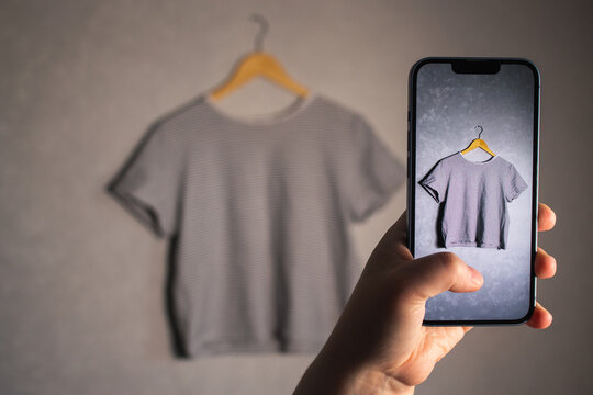 Woman photographs her old outfits for resale. Online resale platforms. Save planet and ecology concept.
