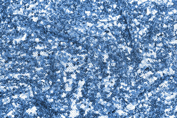 Close-up of shimmering blue spangle fabric with sequins creating a sparkling texture, perfect for fashion, textiles, and luxury design backgrounds.