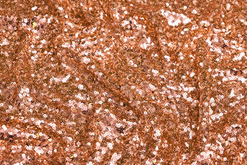 Close-up of shimmering orange spangle fabric with sequins creating a sparkling texture, perfect for fashion, textiles, and luxury design backgrounds.
