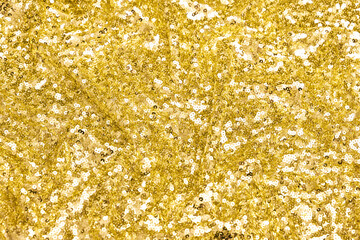 Close-up of shimmering yellow spangle fabric with sequins creating a sparkling texture, perfect for fashion, textiles, and luxury design backgrounds.