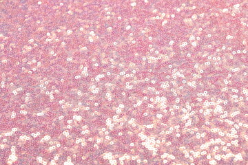 Close-up of shimmering pink spangle fabric with sequins creating a sparkling texture, perfect for fashion, textiles, and luxury design backgrounds.
