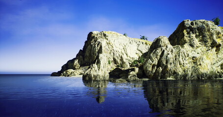 Rocky cliffs rise sharply from the waters edge on a clear, sunny day. The tranquil lake mirrors the cliffs, creating a serene and picturesque landscape.